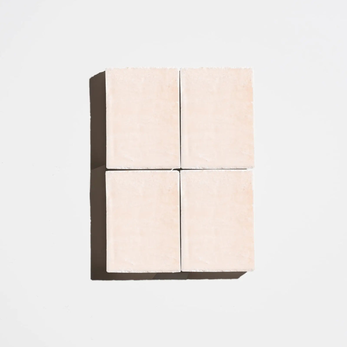 Four square rose-pink natural soap bars arranged in a 2x2 grid on a light background