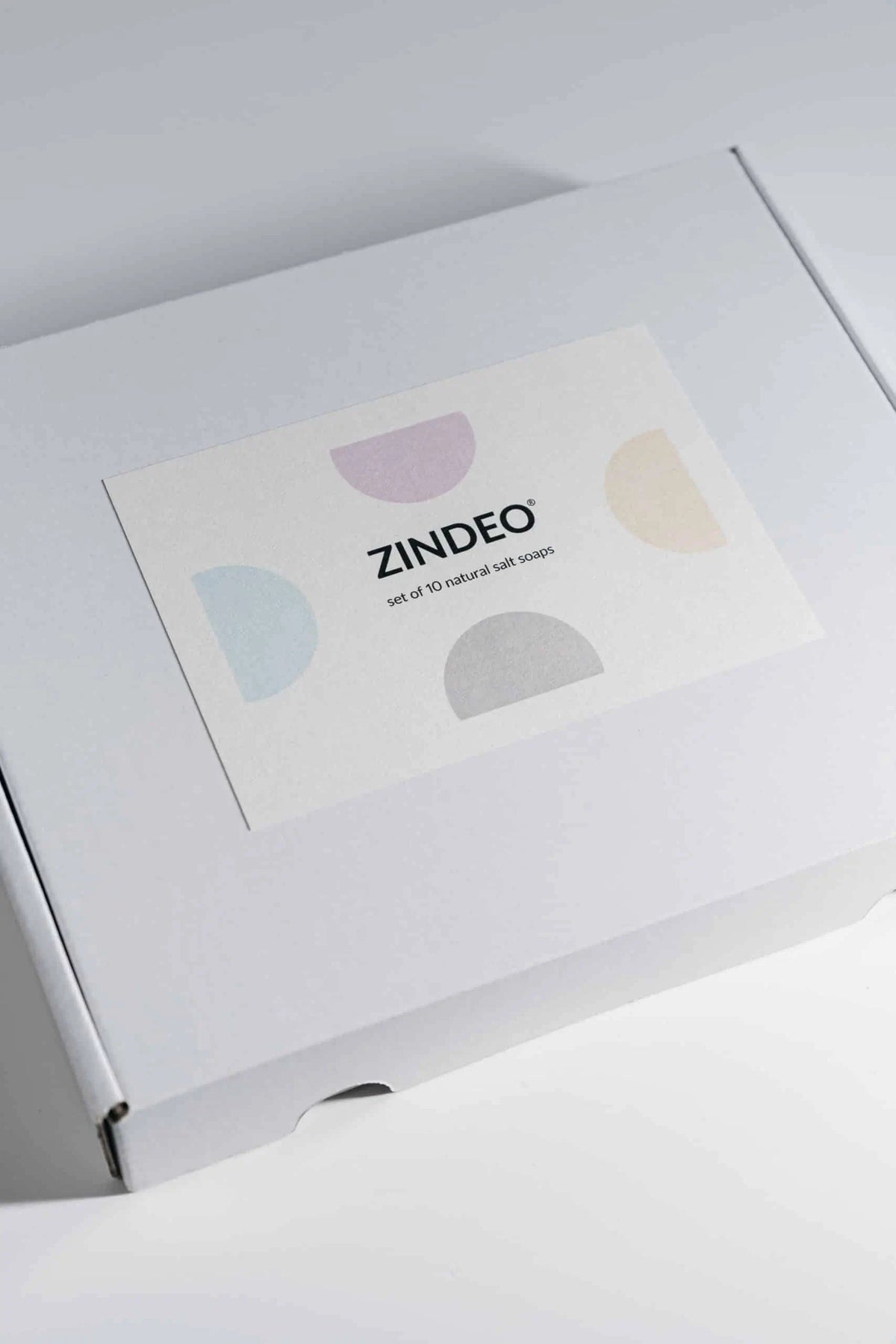 White ZINDEO gift box with a branded salt soaps card and pastel graphics on a light background